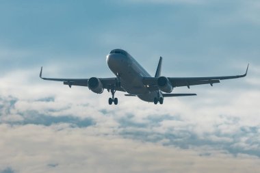 Modern ikiz jet motoru bulutlardan iniyor. Alçaktan uçan yolcu uçağı bir havaalanına inmeye hazır..