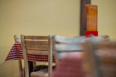 Klasik bir Sırp restoranının tipik iç mimarisi. Masaların ve ahşap sandalyelerin üstü kırmızı kareli..