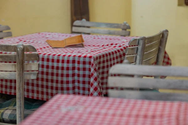 典型的古老风格的塞班人餐厅内部 桌子和木制椅子的红色格子盖 — 图库照片