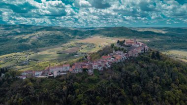 Hırvatistan 'ın İstria kentindeki muhteşem Motovun köyünün hava aracı görüntüsü. Güneşli bir günde hoş, tüylü bulutlar. Idyllic view of picoresque istrian village