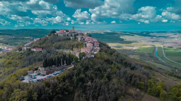 Hırvatistan 'ın İstria kentindeki muhteşem Motovun köyünün hava aracı görüntüsü. Güneşli bir günde hoş, tüylü bulutlar. Idyllic view of picoresque istrian village