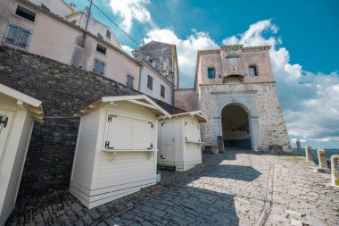 Motovun şehrinin ana giriş kulesine doğru bakın. Hediyelik eşya dükkanları hala kapalı. Güneşli mavi gökyüzü ayarı.