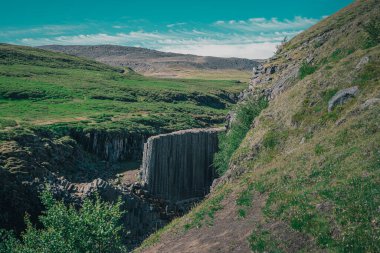 İzlanda 'da Studlagil Kanyonu' nun hava aracı panoraması. Sıcak bir yaz gününde bazalt sütunları yüksekte duran pitoresk vadi. Basakt kaplanlarının genel görünümü,