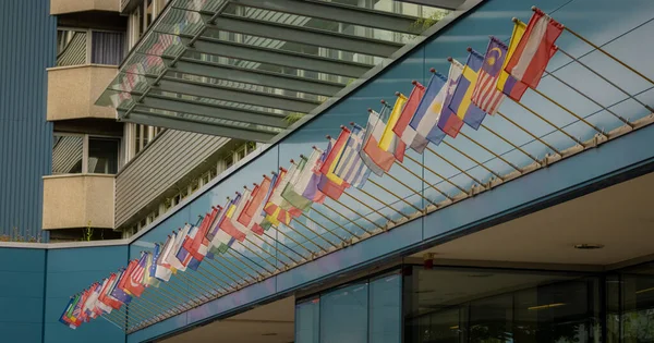 Different flags of all nations in the world collected standing in roe over a hotel entrance.