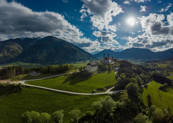Wallfahrtskirche frauenberg is a beautiful church in the middle of Austria, drone panorama view of a church next to enn river in central Austria on a sunny summer day.