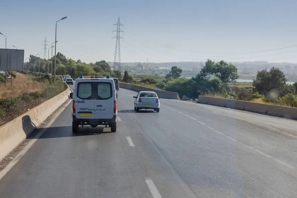 Motorway in algeria, around the city of Oran. View of cars in african city traveling on multi lane highway..  Police car in front