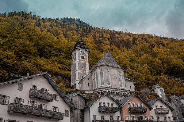 Church rising above the old town of Hallstatt in Central Austria on a cloudy day in autumn. Picturesque village in Austria.