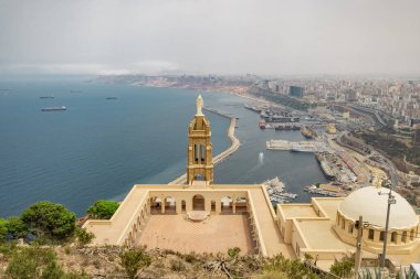 Panoramic view of blessed virgin mary church from Santa Cruz fortress, one of the three forts in Oran, the second largest port of Algeria; Summer day, looking from high above towards the city.