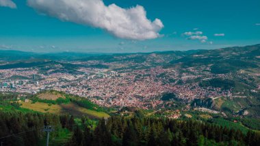 Aerial drone panorama of the city of Sarajevo on a summer day. Viewed from a vantage point close to upper station of gondola or cable car.