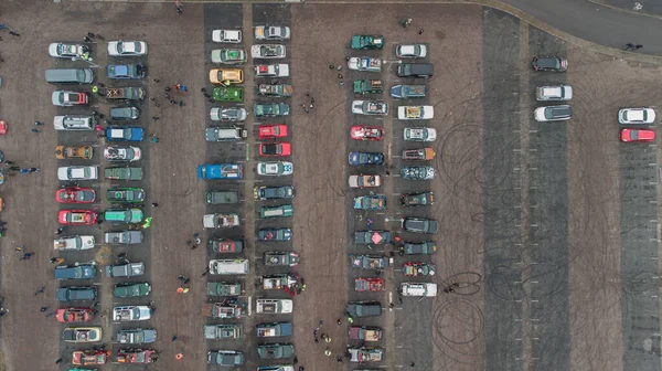 Colorful cars parked on a parking lot viewed from above. Vertical aerial photo of cars on parking.