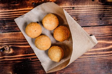 Tahta bir masadaki kağıt zarfın üzerinde patates püresi var. Yakın plan..