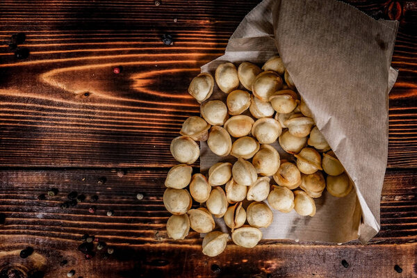 fried dumplings in a paper envelope on a wooden table