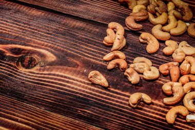 Tahta bir masaya bir avuç kaju serpiştirilmiş. yazıt için yer