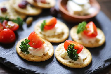 Aperatifler ve atıştırmalıklar, krakerler, kurutulmuş meyve, domates, maydanoz ve krem peynir.