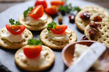 Aperatifler ve atıştırmalıklar, krakerler, kurutulmuş meyve, domates, maydanoz ve krem peynir.