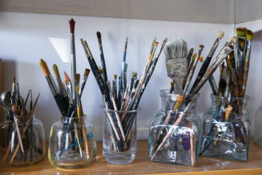 Akrilik renkleri karıştıran eller. Kirli boya tüpleri. Boya fırçalarını kapat. Boş kopyalama alanı