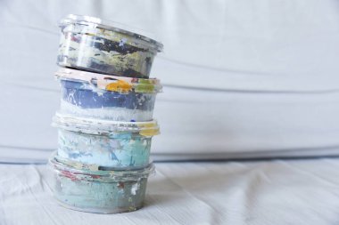 Akrilik renkleri karıştıran eller. Kirli boya tüpleri. Boya fırçalarını kapat. Boş kopyalama alanı