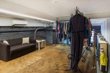 A modern showroom in a loft with a comfortable gray sofa and a small table.