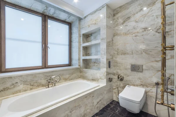 Luxurious Bathroom Decorated Beige Marble Tiles White Bathtub Window — стоковое фото