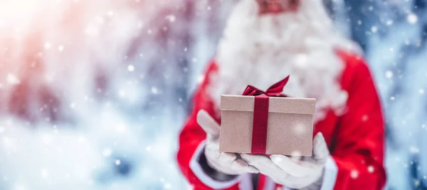 Święty Mikołaj trzyma w dłoniach pudełko prezentów. — Zdjęcie stockowe