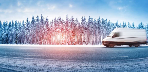 Furgoneta blanca moviéndose en un camino de asfalto resbaladizo en nevadas —  Fotos de Stock