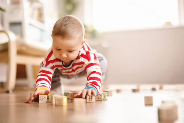 Kleines Baby spielt mit Spielzeug auf dem Fußboden. — Stockfoto