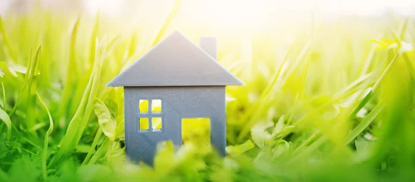 Plastikmodell des Hauses auf dem frischen Gras an einem sonnigen Tag. — Stockfoto