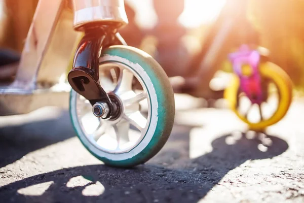 Boyfriends riding on scooters on asphalt road in summer. — Stock Fotó