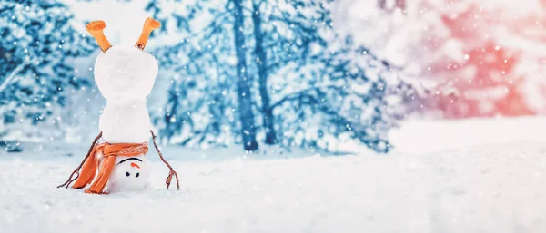 Cheerful snowman with orange scarf and in yellow boots stands upside down in winter — Foto Stock