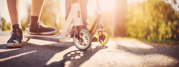 Boyfriends riding on scooters on asphalt road in summer. — Zdjęcie stockowe