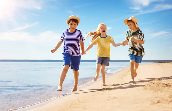 Söta barn som springer längs havskusten — Stockfoto