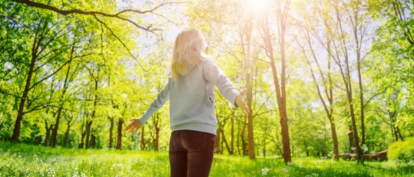 Donna in piedi nel parco naturale primaverile con le mani spalancate. — Foto Stock