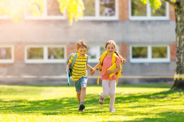 Мальчик и девочка бегут в школу — стоковое фото