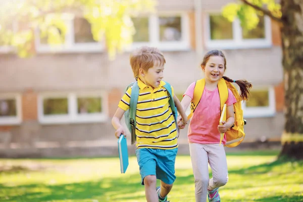 Мальчик и девочка бегут в школу — стоковое фото