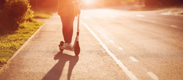 Woman riding on scooter on asphalt road in summer — ストック写真