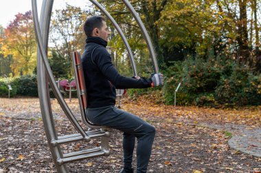 Sonbaharda dışarıdaki güç istasyonunda egzersiz yapan genç bir adam..