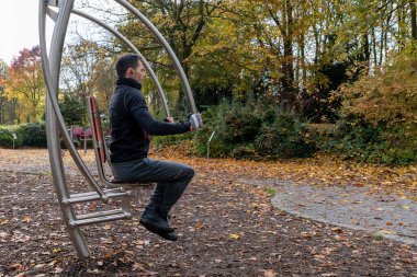 Sonbaharda dışarıdaki güç istasyonunda egzersiz yapan genç bir adam..