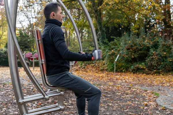 Sonbaharda dışarıdaki güç istasyonunda egzersiz yapan genç bir adam..