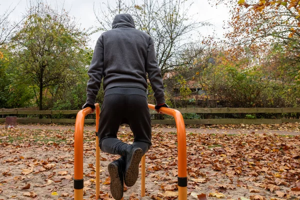 Antrenman, sporcu yatay çubuğu kaldırır, dışarıda, sonbaharda.