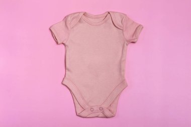 Pembe, boş, bebek giysisi şablonu, yakın plan pembe arka plan. Bebek kıyafeti, yeni doğanlar için tulum. Yukarıdan görüntüle