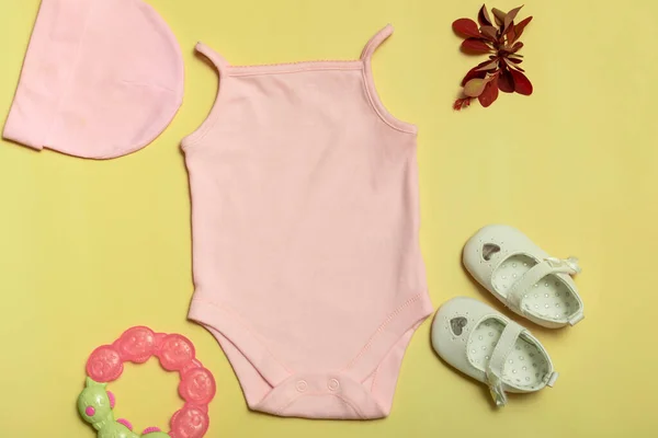 Logoların tasarımı ve yerleştirilmesi için bir model, reklamcılık. Pembe bebek tulumu, üst manzara, sarı arka planda model..