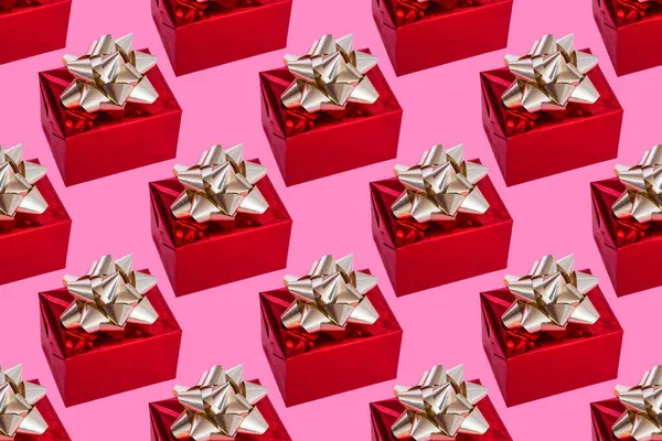 Le jour de la boxe. composition de Noël. Cadeau rouge avec un arc en or sur un fond rose. modèle. — Photo