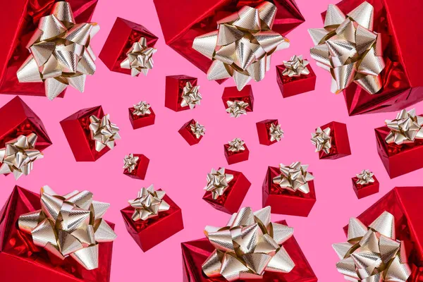 Le jour de la boxe. composition de Noël. Cadeau rouge avec un arc en or sur un fond rose. modèle. — Photo