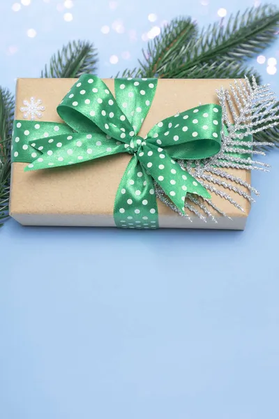 メリークリスマスとハッピーニューイヤー ライトのある青の背景に水玉や装飾が施された緑のリボンを贈ってください コピースペース付きの休日カードを閉じます 垂直写真 ストック画像