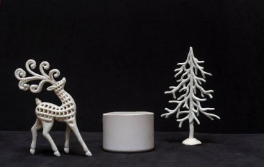 Minimum yeni yıl ya da noel konsepti, geyikli taş podyum ve siyah arka planda noel ağacı. Yakın plan.