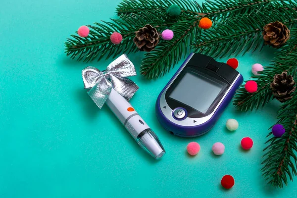 Bayram süslemeleri ve renkli bir arka planda kan şekerini ölçmek için glukometre bulunan Noel afişi. Kopya alanı olan doktorlar için Noel kartı konsepti. Kapat