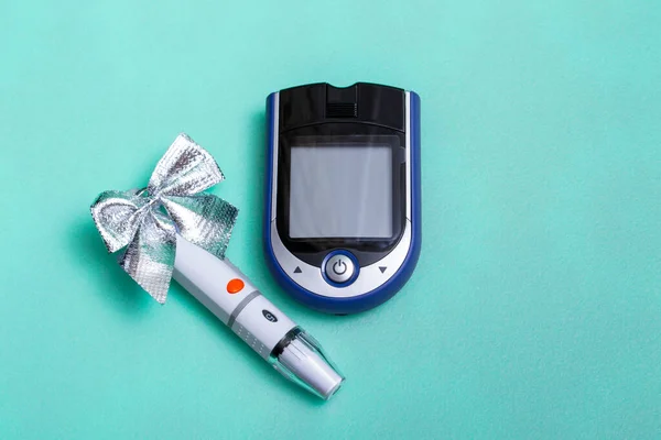 休日の装飾と色の背景に血糖値を測定するための血糖値計を持つクリスマスバナー コピースペースの医者のためのクリスマスカードの概念 閉じる ロイヤリティフリーのストック画像