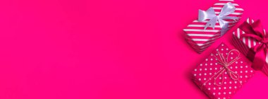 Pembe çizgili beyaz bir hediye ve pembe arka plan fotokopi alanındaki beyaz noktalar. Pankart