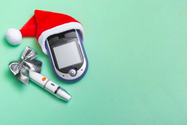 Tatil süslemeleri, Noel Baba şapkası ve kan şekeri sayacı olan bir Noel afişi. Kopya alanı olan doktorlar için Noel kartı konsepti. Kapat