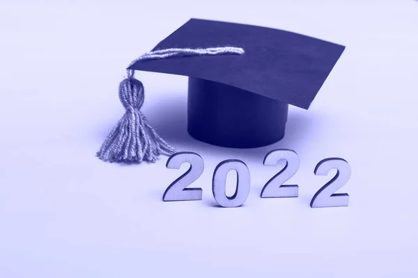 Mezuniyet şapkası şeklinde bir hediye kutusu. 2022 sürüm kavramı kopya alanı ile çok peri arkaplanı